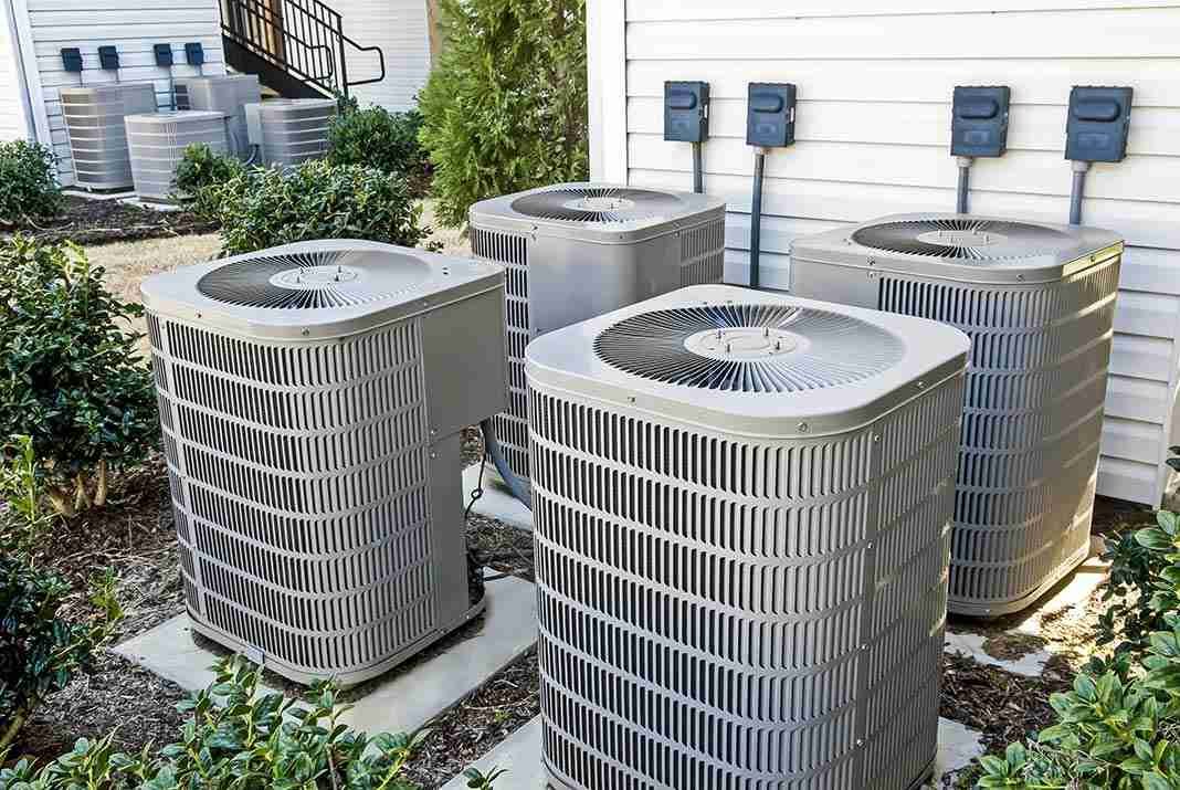 Residential central air conditioning units efficiently lined up outside a home, ready to beat the heat.