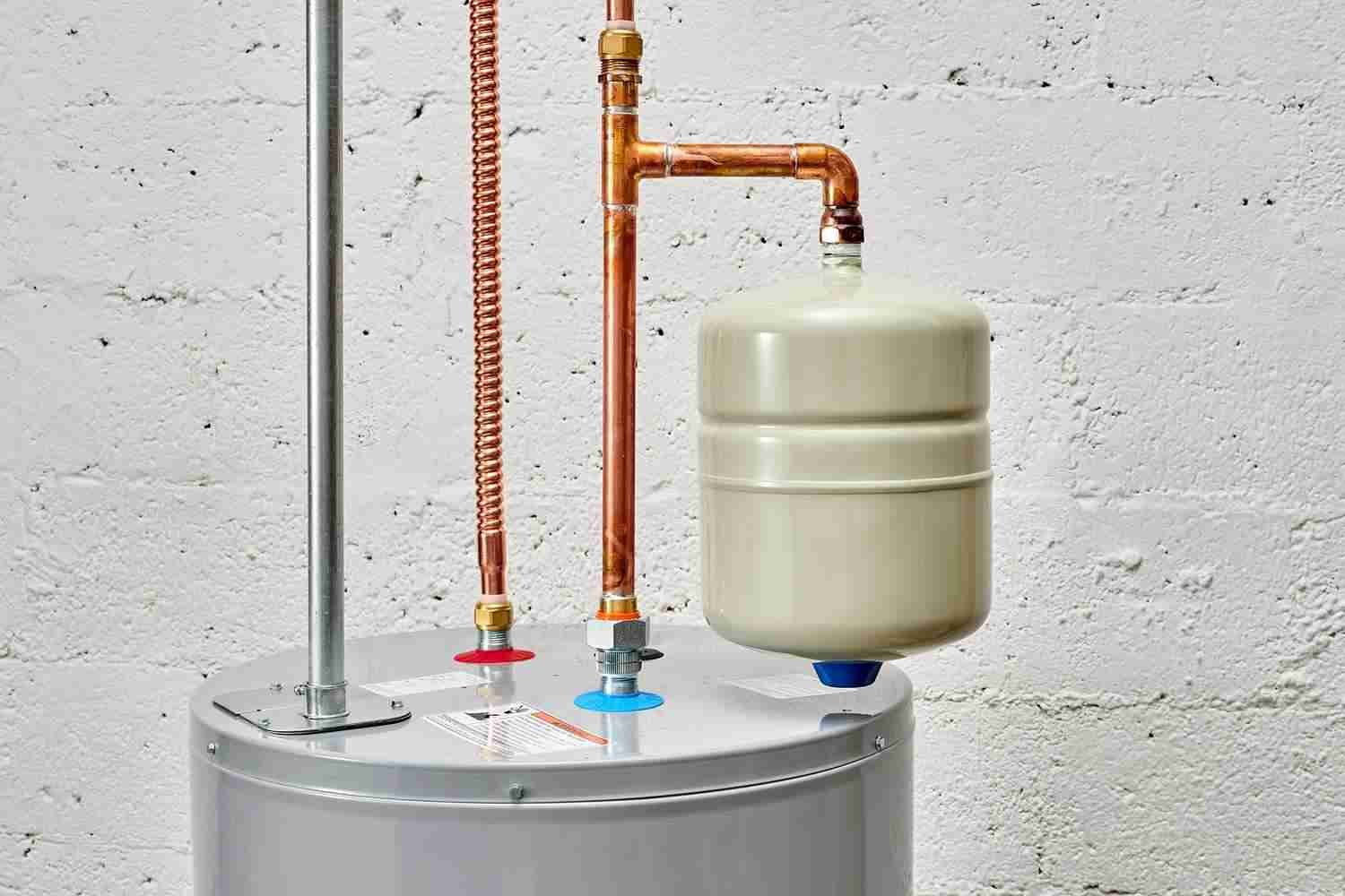 A close-up of a modern home water heater setup with copper piping and an expansion tank against a white brick wall.